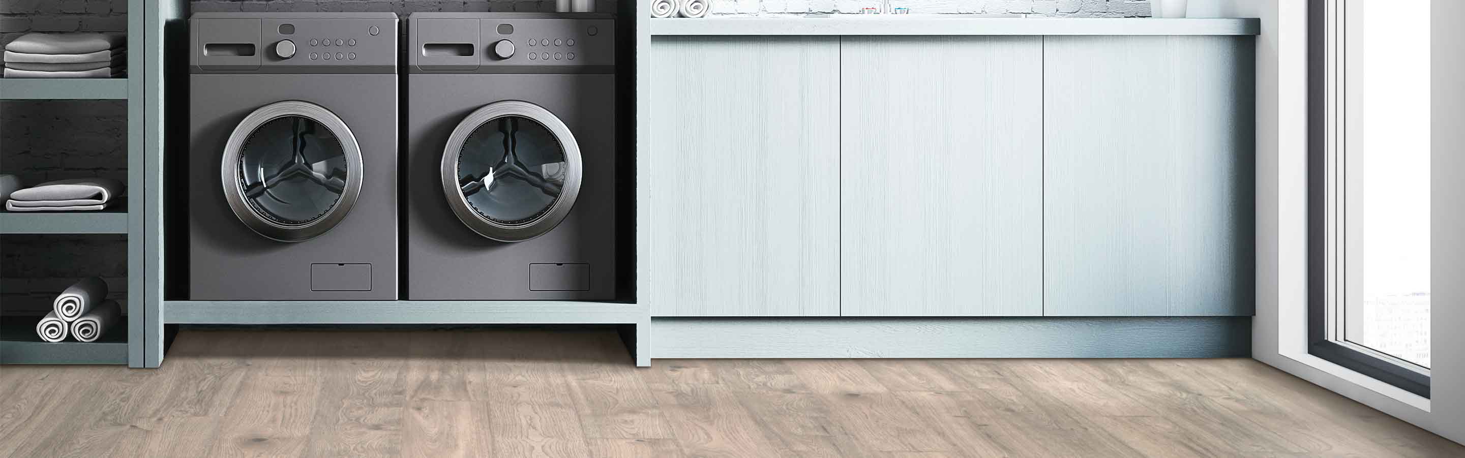 gray wood look laminate flooring in downstairs laundry room with gray washer and dryer and sink